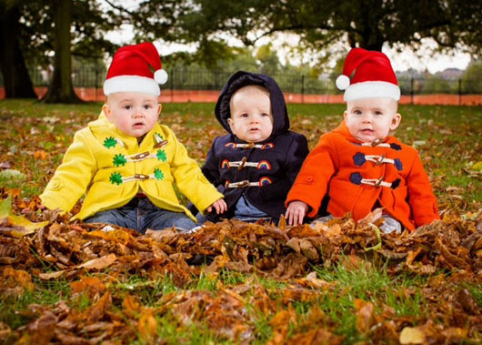 three babies sat in autumn leaves wearing Cololo fun and colourful babyswear jackets